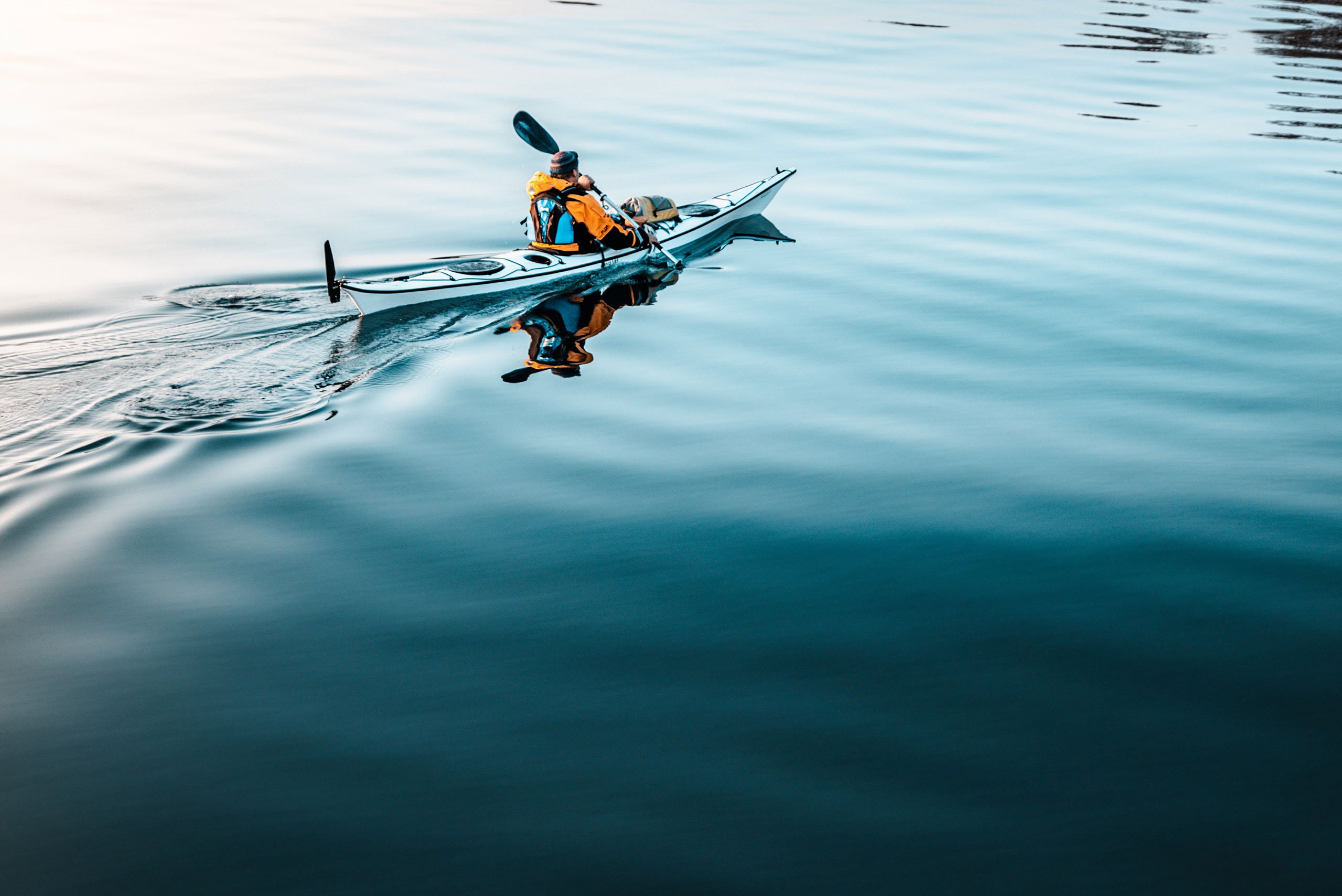 Imagen de hombre remando en kayak en una mar calmado